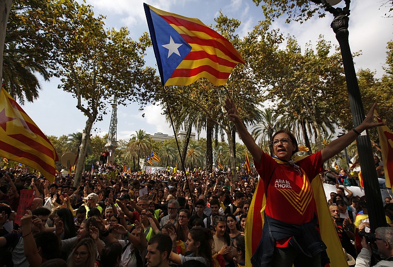 
              A woman gestures as others wave the ''estelada'' or Catalonia independence flags during a protest in Barcelona, Spain Thursday, Sept. 21, 2017. The Catalan regional government says that a top official in the management of the region's economic affairs has been arrested as a crackdown intensifies on preparations for a secession vote that Spanish authorities have suspended. (AP Photo/Emilio Morenatti)
            
