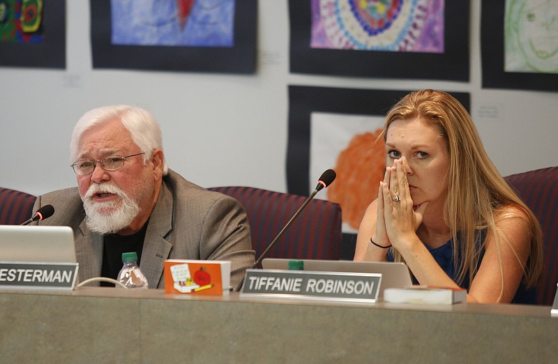 Board member Tiffanie Robinson, right, listens as board member David Testerman voices his opposition to a state partnership zone for low performing schools during a meeting of the Hamilton County Board of Education on Thursday, Sept. 21, 2017, in Chattanooga, Tenn.