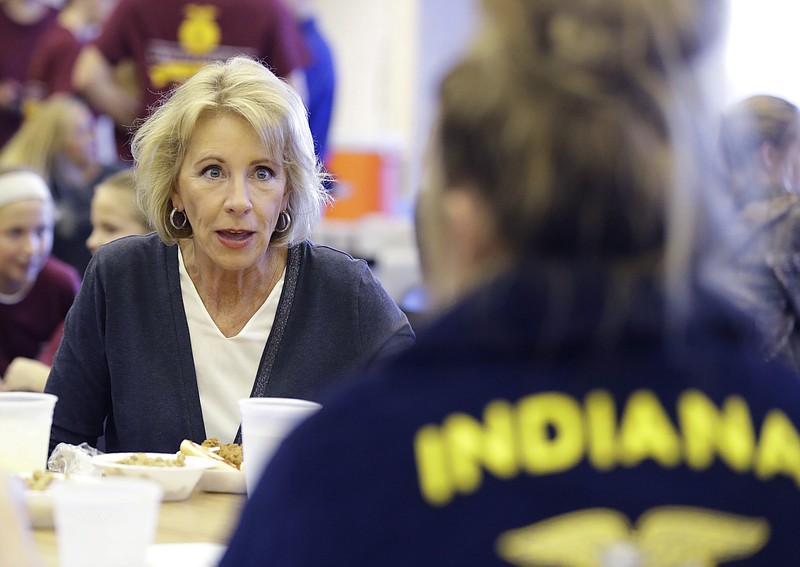 
              In this Sept. 15, 2017 photo, U.S. Secretary of Education Betsy DeVos talks with Gracie Johnson during a hog roast before a high school football game between Eastern Hancock and Knightstown in Charlottesville, Ind. DeVos uses a private jet to fly around the country to tour schools and attend other work events, the Associated Press has learned.  (AP Photo/Darron Cummings)
            