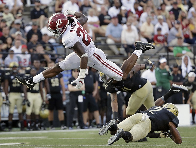 Alabama running back Najee Harris (22) leaps over Vanderbilt safety Arnold Tarpley III (2) in the second half of an NCAA college football game Saturday, Sept. 23, 2017, in Nashville, Tenn. (AP Photo/Mark Humphrey)