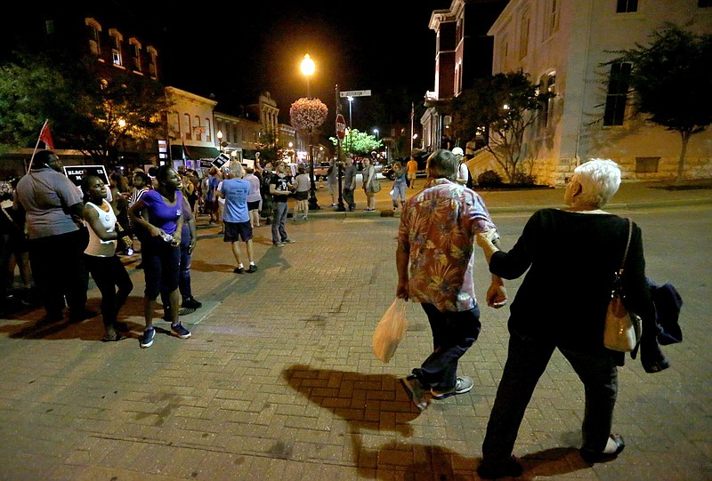 
              A man is pulled away from yelling at protesters as they rally over the recent the acquittal of a white former police officer, Jason Stockley, in the killing of a black man, Anthony Lamar Smith, who was a drug suspect, in St. Charles, Mo., Friday, Sept. 22, 2017. Nearly 150 protesters gathered outside the St. Louis Outlet Mall in Hazelwood, but the mall and all its stores had closed early because of the planned demonstrations. Organizers had everyone carpool to nearby St. Charles, which was overrun with thousands of people attending an Oktoberfest event. (Christian Gooden/St. Louis Post-Dispatch via AP)
            