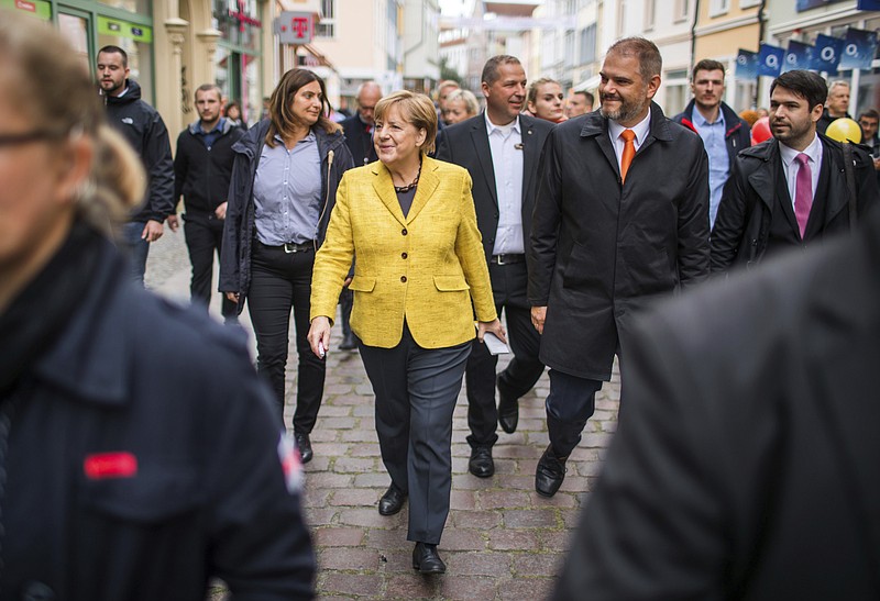 
              German chancellor Angela Merkel, front left, is accompanied by Stralsund mayor  Alexander Badrow, third right, as she takes a stroll through the old town of Stralsund, at the Baltic Sea, Germany, Saturday, Sept. 23, 2017 one day ahead of Germany's general elections on Sunday.  (Jens Buettner/dpa via AP)
            