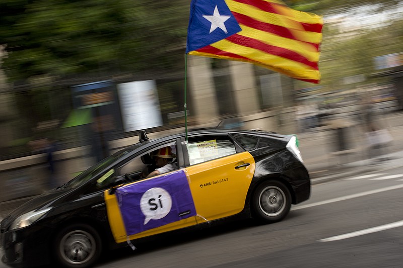 
              A man drives his taxi decorated with an estela flag and publicity supporting the Oct. 1 vote in Barcelona, Spain Friday, Sept. 22, 2017. Spain will deploy police reinforcements to Catalonia to help maintain order if an independence referendum pledged by Catalan officials but opposed by the national government goes ahead, officials said Friday. (AP Photo/Emilio Morenatti)
            