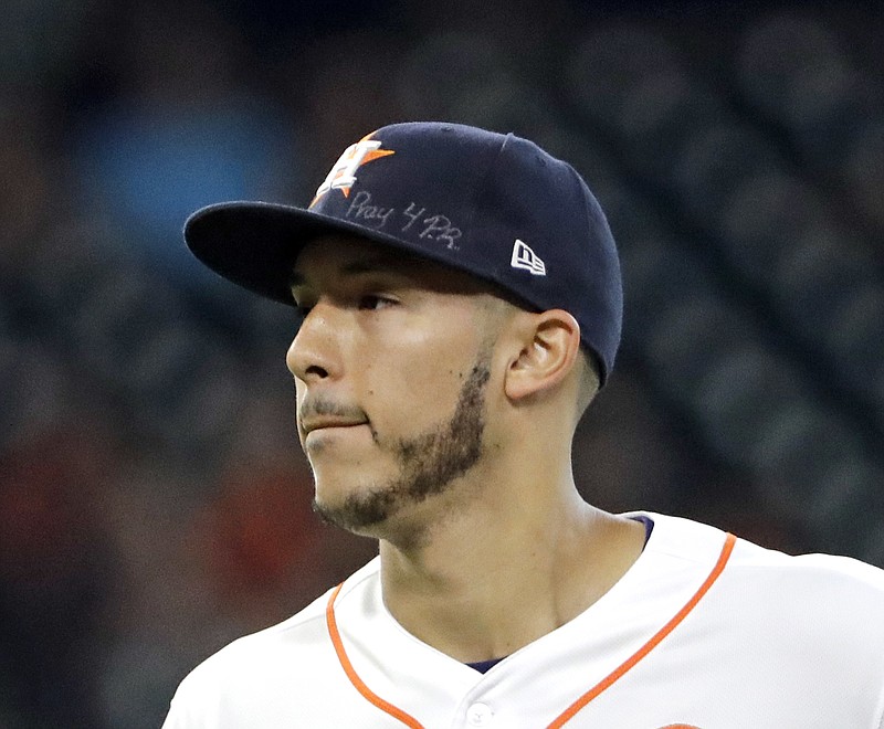 
              Houston Astros shortstop Carlos Correa wears messages on his cap for those affected by disasters in Mexico and Puerto Rico during the second inning of a baseball game Saturday, Sept. 23, 2017, in Houston. (AP Photo/David J. Phillip)
            