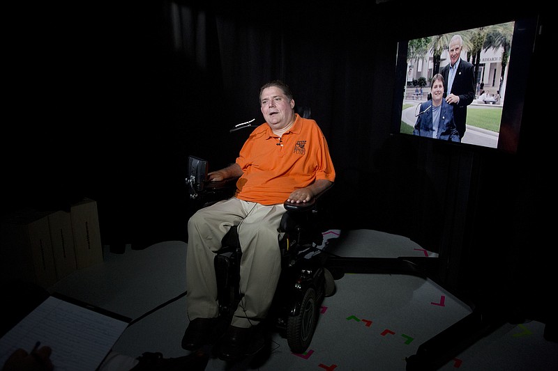 
              In this Tuesday, Sept. 19, 2017 photo,  Marc Buoniconti talks during an interview in New York. On the right is a photograph of the former Citadel player with his father, Nick Buoniconti. Buoniconti wants to see youth football banned. A former college player who was paralyzed during a game and now a spokesman for the Miami Project, Buoniconti believes children's brains are put in jeopardy with every hit.  (AP Photo/Mark Lennihan)
            