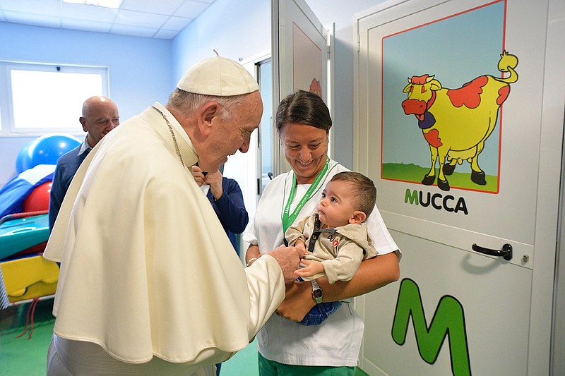 
              Pope Francis talks to an infant during his visit to the Santa Lucia Foundation in Rome, Friday, Sept. 22, 2017. (L'Osservatore Romano/Pool Photo via AP)
            