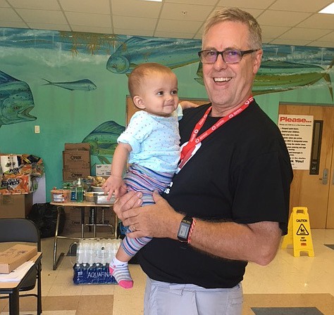 Rev. Brad Whitaker, from St. Paul's Episcopal Church in Chattanooga, serves a young client at a Red Cross shelter. He is serving as spiritual care lead with the Red Cross in Marathon, Florida.