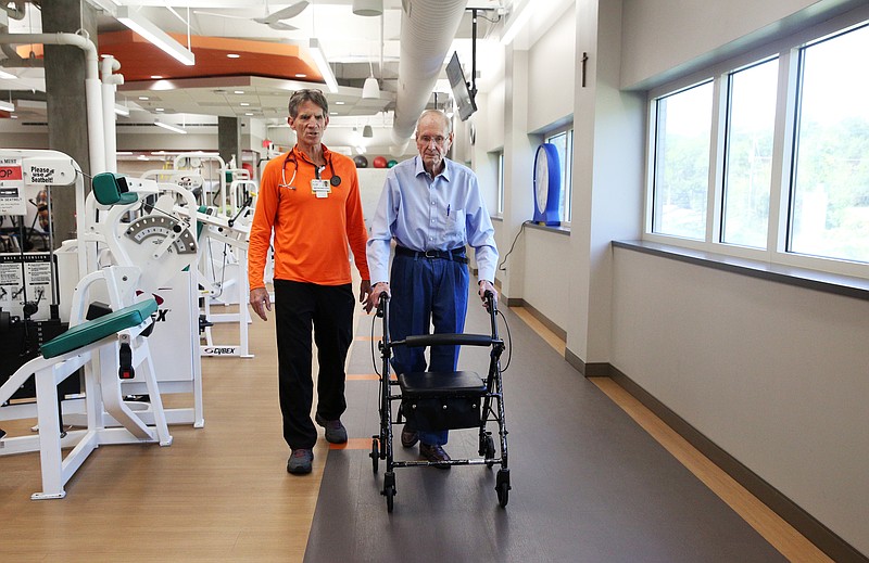 Allan Lewis, director of cardiac rehab, walks with Donald Seesenguth, a patient who recently underwent MitraClip surgery, around the track at CHI Memorial Hospital on Monday, Sept. 18, 2017. A walk test is required of the patient pre and post surgery. 