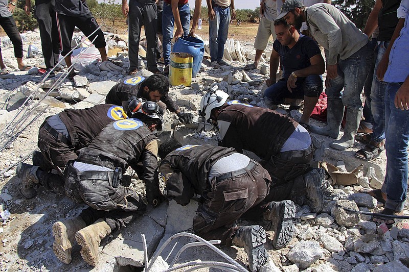 
              This photo provided by the Syrian Civil Defense White Helmets, which has been authenticated based on its contents and other AP reporting, shows civil defense workers searching in the rubble after airstrikes hit in Khan Sheikhoun, in the northern province of Idlib, Syria, Sunday, Sept, 24, 2017. A Syrian war monitoring group says airstrikes have targeted rural Aleppo for the first time in months since a cease-fire took hold in the province. (Syrian Civil Defense White Helmets via AP)
            