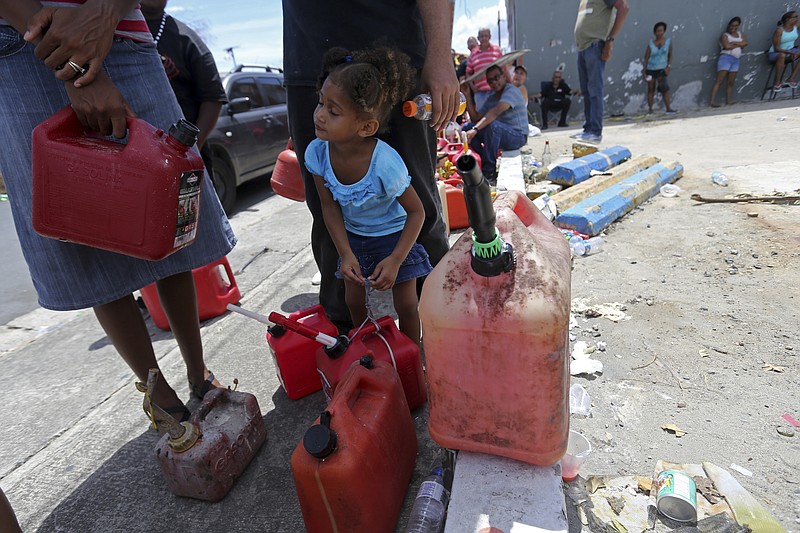 
              Abi de la Paz de la Cruz, 3, holds a gas can as she waits in line with her family, to get fuel from a gas station, in the aftermath of Hurricane Maria, in San Juan, Puerto Rico, Monday, Sept. 25, 2017. The U.S. ramped up its response Monday to the humanitarian crisis in Puerto Rico while the Trump administration sought to blunt criticism that its response to Hurricane Maria has fallen short of it efforts in Texas and Florida after the recent hurricanes there. (AP Photo/Gerald Herbert)
            