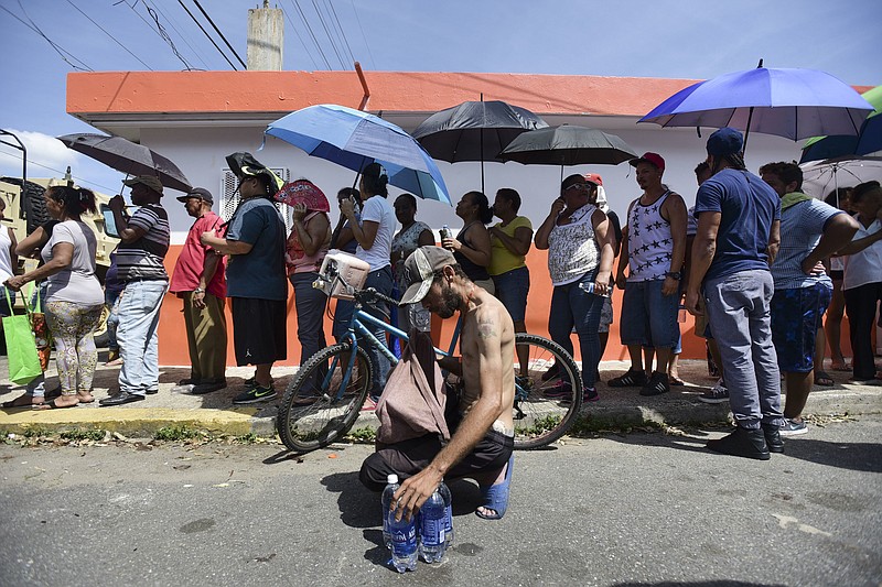 
              In this Sunday, Sept. 24, 2017, file photo, people affected by Hurricane Maria wait in line at Barrio Obrero to receive supplies from the National Guard, in San Juan, Puerto Rico. Maria has devastated Puerto Rico, destroying buildings and leaving its more than 3.4 million residents largely without power. Food and drinking water are also difficult to come by, and the recovery will be long, difficult and expensive. (AP Photo/Carlos Giusti, File)
            