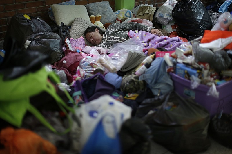 
              A woman sleeps at the Francisco Kino school, which was turned into a temporary shelter for residents evacuated from the large apartment complex, in the Tlalpan neighborhood of Mexico City, Monday, Sept. 25, 2017.  The 7.1 magnitude quake on Sept. 19 left the complex's 500 residents, mostly government employees, without a home after one of the 11 buildings collapsed and the others were damaged. (AP Photo/Natacha Pisarenko)
            