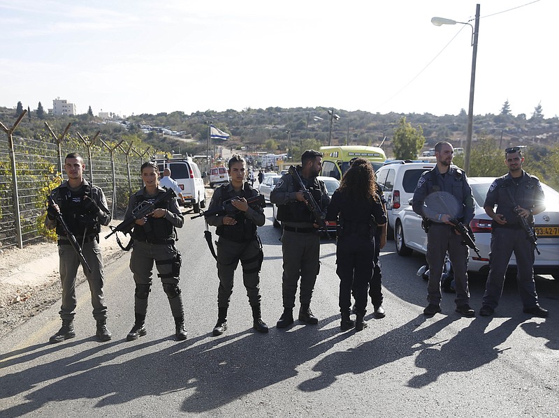 
              Israeli police blocks the road to Har Adar settlement near Jerusalem, Tuesday, Sept. 26, 2017. Israeli police said that a Palestinian attacker opened fire at the entrance to the settlement killing three Israeli men and critically wounding a fourth. (AP Photo/Mahmoud Illean)
            