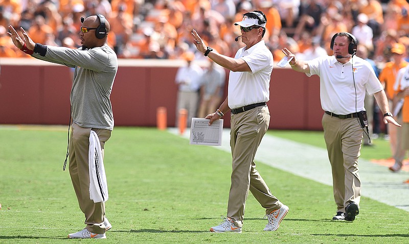 From left, Tennessee coaches Robert Gillespie, Mike Canales and Butch Jones send signals to the offense during this past Saturday's home win against UMass. The Vols lost yardage on first down six times in the 17-13 victory, and avoiding such setbacks will be crucial this weekend against No. 7 Georgia, Jones said.