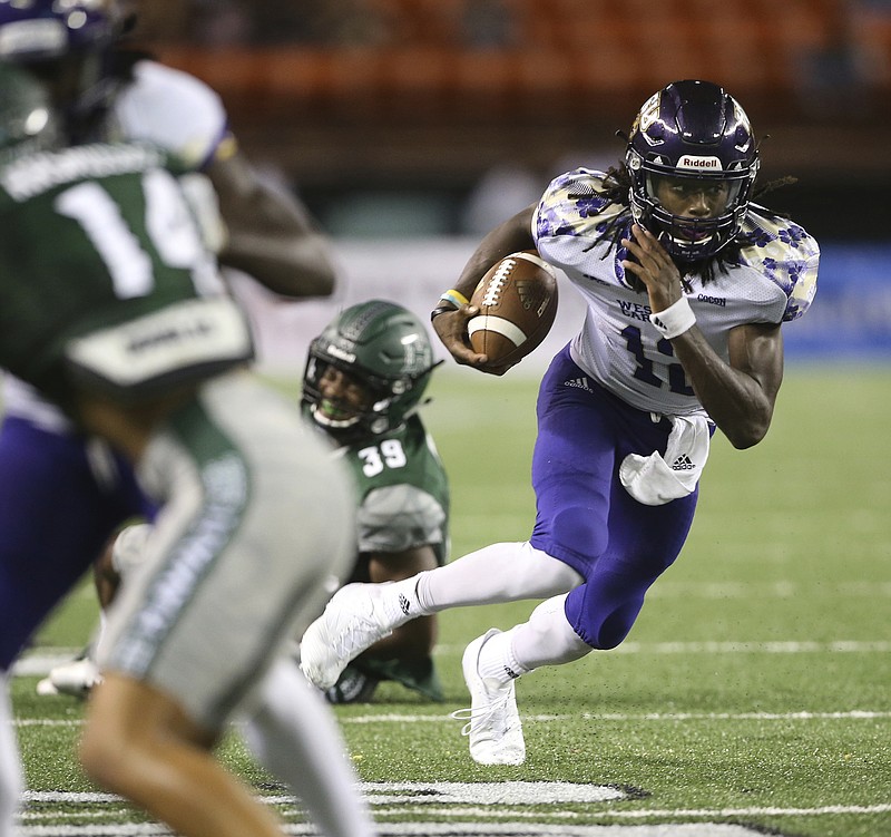 Western Carolina quarterback Tyrie Adams runs through the Hawaii defense during their game this month in Honolulu. Adams and the Catamounts visit UTC for a SoCon matchup Saturday night at Finley Stadium.