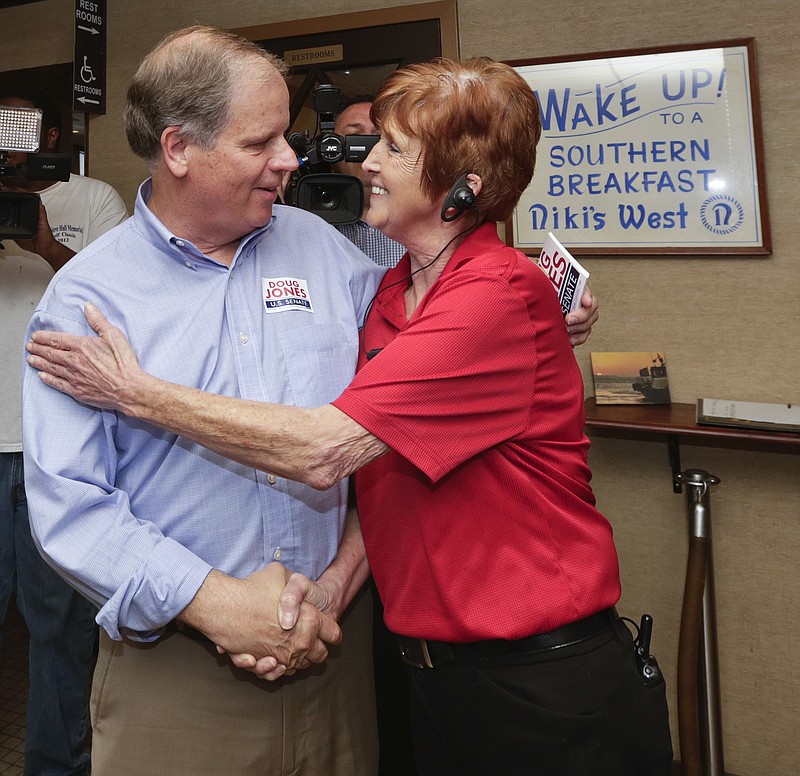 
              Democratic Senate candidate Doug Jones, left, hugs supporter Dianne Simmons, right, as he campaigns at Niki's West restaurant, Wednesday, Sept. 27, 2017, in Birmingham, Ala. Jones will face former Alabama Chief Justice and U.S. Senate candidate Roy Moore. (AP Photo/Brynn Anderson)
            