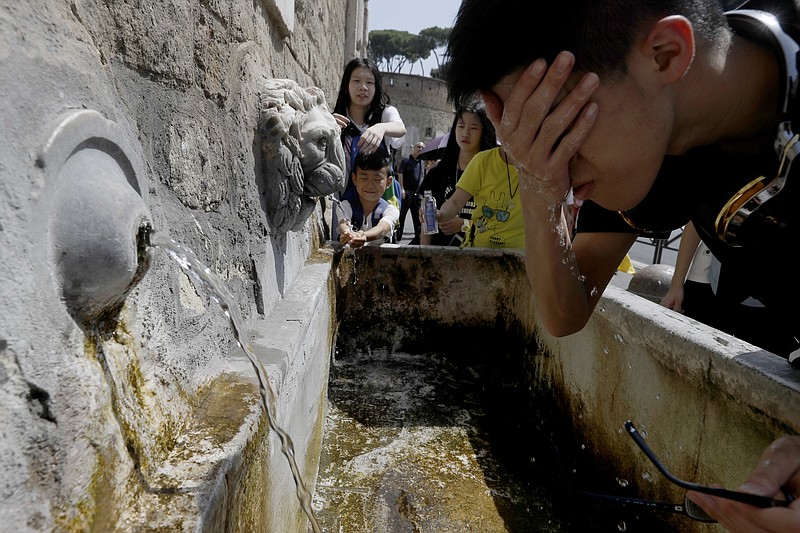 
              In this Aug. 9, 2017 file photo tourists refresh themselves at a fountain in Rome.  A relentless heat wave that gripped parts of Europe has sent temperatures soaring to record highs for several days. Researchers say the likelihood of scorching summer temperatures in southern Europe is increasing because of man-made climate change. Hotter-than-usual temperatures in the Mediterranean region - including an August heatwave in Italy and the Balkans dubbed ‘Lucifer’ - resulted in higher hospital admissions, numerous forest fires and widespread economic losses this summer.  (AP Photo/Gregorio Borgia,file)
            