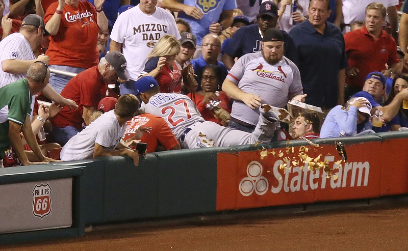 
              Chicago Cubs shortstop Addison Russell knocks over a fan's tray of nachos as he falls into the stands reaching for a foul ball hit by St. Louis Cardinals' Jedd Gyorko during the second inning of a baseball game Monday, Sept. 25, 2017, at Busch Stadium in St. Louis. Russell was unable to make the catch and Gyorko subsequently hit a solo home run. (Chris Lee/St. Louis Post-Dispatch via AP)
            