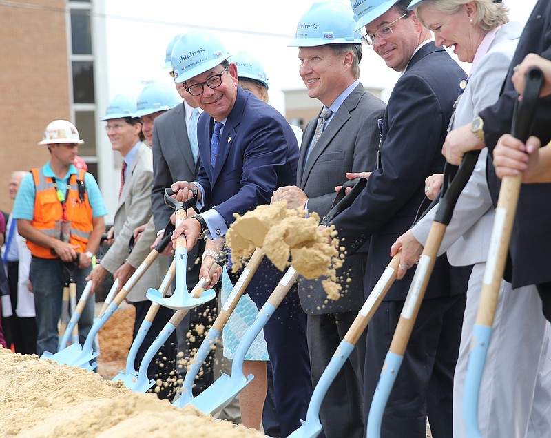 President and Chief Executive Officer for the Erlanger Health System Kevin Spiegel playfully tosses sand in the direction of others Tues., June 6, 2017, during the ground breaking ceremony at the site for the new Erlanger Children's Hospital on Third Street in Chattanooga