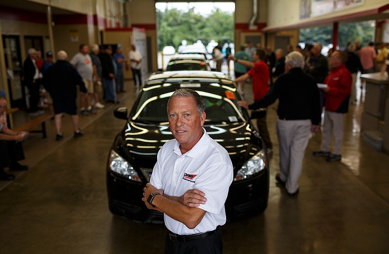 CEO Doug Rodrigues poses for a photograph in front of the auction line during a car auction at Dealers Auto Auction on Thursday, Sept. 14, 2017, in Chattanooga, Tenn. Auto dealers bid for cars in monthly auto auctions that are also webcast for online bidding.