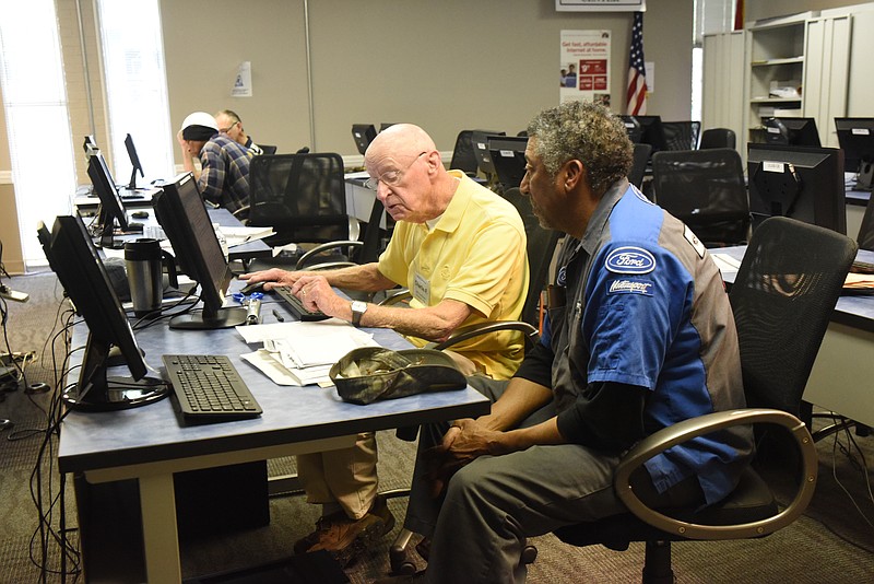 A Volunteer Income Tax Assistance preparer works with a client on his income tax return at the Urban League.