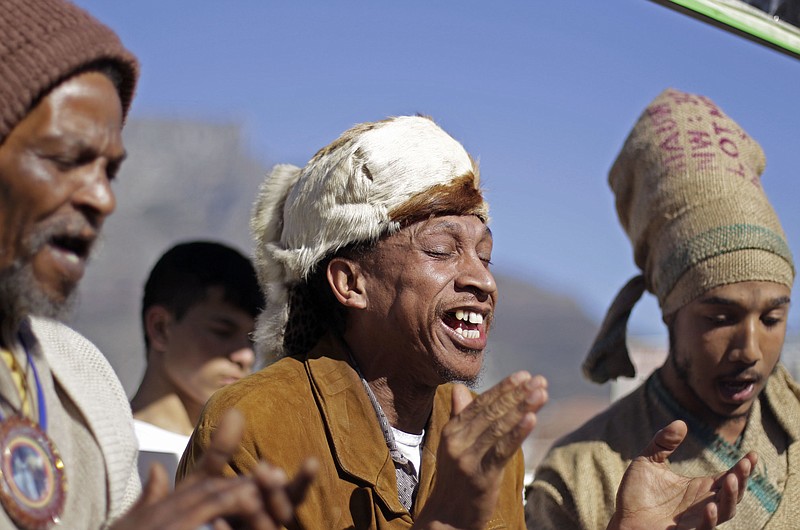 
              FILE - In this Thursday, June 28, 2012 file photo, men from the Khoisan ethnic group sing in Cape Town, South Africa, during an event unveiling a new suggested name by them for Cape Town, which translates as, "Where the clouds gather." The Khoisan gathering placed emphasis on there race and ethnicity in South Africa. In a paper released Thursday, Sept. 28, 2017 by the journal Science, Mattias Jakobsson of Uppsala University in Sweden and co-authors put the earliest split in Homo sapiens they could detect at 260,000 to 350,000 years ago. That’s when ancestors of today’s Khoisan peoples diverged from the ancestors of other people, they calculated. (AP Photo/Schalk van Zuydam)
            