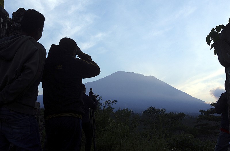 
              Villagers watch Mount Agung from an observation point which is about 12 kilometer (7.4 miles) away from the volcano in Karangasem, Bali, Indonesia, Thursday, Sept. 28, 2017. The exodus from the menacing volcano on the Indonesian tourist island is nearing 100,000 people, a disaster official said Wednesday, as hundreds of tremors from the mountain are recorded daily. (AP Photo/Firdia Lisnawati)
            