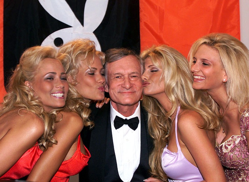 In this May 14, 1999, file photo, Playboy founder and editor in chief Hugh Hefner receives kisses from Playboy playmates during the 52nd Cannes Film Festival in Cannes, France. Hefner has died at age 91. The magazine released a statement saying Hefner died at his home in Los Angeles of natural causes on Wednesday night, Sept. 27, 2017, surrounded by family. (AP Photo/Laurent Rebours, File)