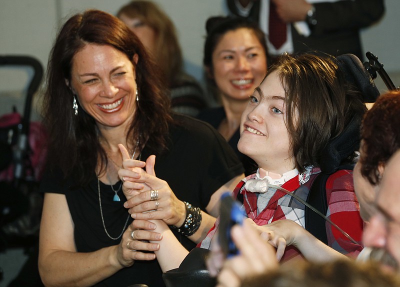 
              FILE - In this Monday, March 18, 2015 file photo, fourteen-year-old Jack Splitt, right, celebrates with his mother, Stacey Linn, as Colorado Governor John Hickenlooper signs a bill named after the young man from Wheat Ridge, Colo., to crack down on the state's medical marijuana industry in southeast Denver. Mark Pedersen, a man who made cannabis oil for Jack Splitt who was instrumental in passing a state law requiring schools to allow students to use medical marijuana is facing several felony drug charges.  (AP Photo/David Zalubowski, File)
            