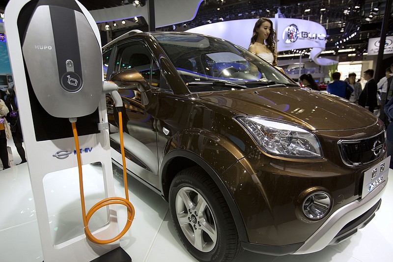 
              FILE - In this April 26, 2016, file photo, a staff member stands next to an e.Cool electric SUV by Chinese automaker Changjiang on display at the Beijing International Automotive Exhibition in Beijing. China has stepped up pressure on automakers to accelerate development of electric cars by raising the first-year target for a planned system of production quotas but delayed its rollout until 2019. (AP Photo/Mark Schiefelbein, File)
            