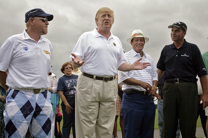 
              FILE - In this March 9, 2010, file photo, Second from left to right Donald Trump presents PGA players, John Daly, far left and Rocco Mediate, far right, as PGA senior player Chi-Chi Rodriguez of Puerto Rico, third from left to right, act as the tournament ambassador during a celebrity golf match between Daly and Mediate at the Trump International Golf Club in Rio Grande, Puerto Rico. The AP reported Sept. 29, 2017, that stories being shared online claiming Trump defaulted on a municipal bond when the club filed for bankruptcy are inaccurate. (AP Photo/Ricardo Arduengo, File)
            