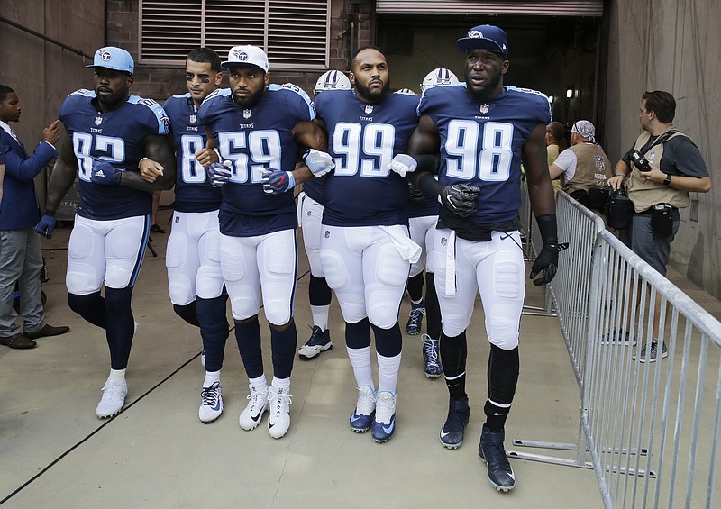 
              FILE - In this Sept. 24, 2017, file photo, Tennessee Titans’ Delanie Walker (82), Marcus Mariota (8), Wesley Woodyard (59), Jurrell Casey (99) and Brian Orakpo (98) walk to the field with arms linked after the national anthem had been played before an NFL football game against the Seattle Seahawks in Nashville, Tenn. Walker says he and his family have received death threats since he told fans not to come to games if they felt disrespected by NFL players' protests. Walker shared the threats Thursday night, Sept. 28, 2017, in a social media post. (AP Photo/James Kenney, File)
            