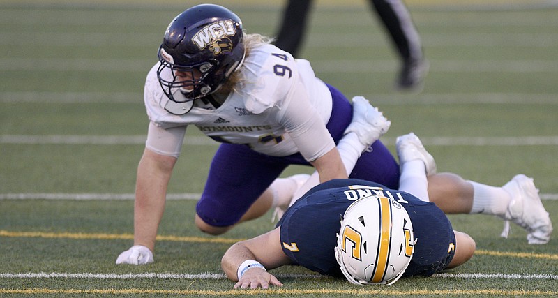 UTC quarterback Nick Tiano (7) lies on the turf after being hit by Western Carolina defensive tackle Jake Helms (94) at Finley Stadium on Saturday, Sept. 30, in Chattanooga, Tenn.