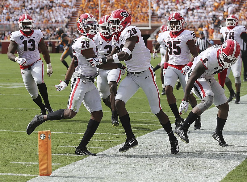 Georgia defensive backs Tyrique McGhee (26) and J.R. Reed (20) celebrate McGhee's interception of Tennessee's Quinten Dormady on the first play from scrimmage during Saturday's 41-0 win by the Bulldogs in Knoxville. The Bulldogs moved up to fifth in the latest AP rankings.