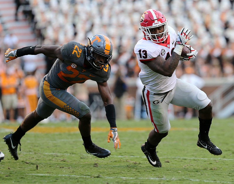 University of Tennessee's Micah Abernathy (22) misses a tackle on University of Georgia's Elijah Holyfield (13) during the University of Tennessee vs. University of Georgia football game at Neyland Stadium in Knoxville, Tenn., Saturday, Sept. 30, 2017.  