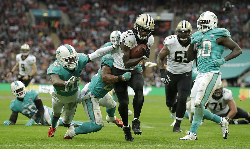 
              New Orleans Saints running back Alvin Kamara (41) runs past Miami Dolphins defenders to score a touchdown during the second half of an NFL football game at Wembley Stadium in London, Sunday Oct. 1, 2017. (AP Photo/Matt Dunham)
            