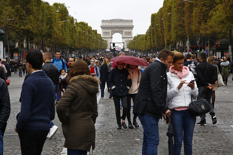 
              People walk on the champs Elysees avenue during the "day without cars", with the Arc de Triomphe in background, in Paris, France, Sunday, Oct. 1, 2017.  Parisians and tourists are being encouraged to stroll through the city as officials have banned cars from its streets for a day, the first time the entire city is being handed over to ramblers, cyclists and roller-bladers. (AP Photo/Thiabult Camus)
            