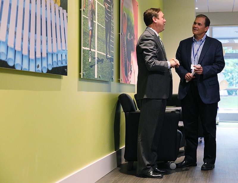 Charles H. Wood (left), vice president of Economic Development at the Chattanooga Area Chamber, speaks with Roger Posacki, president and chief executive officer of PlayCore, Thursday, June 29, 2017, during PlayCore's grand opening event in Chattanooga, Tenn. PlayCore signed a 10-year lease in the new space.