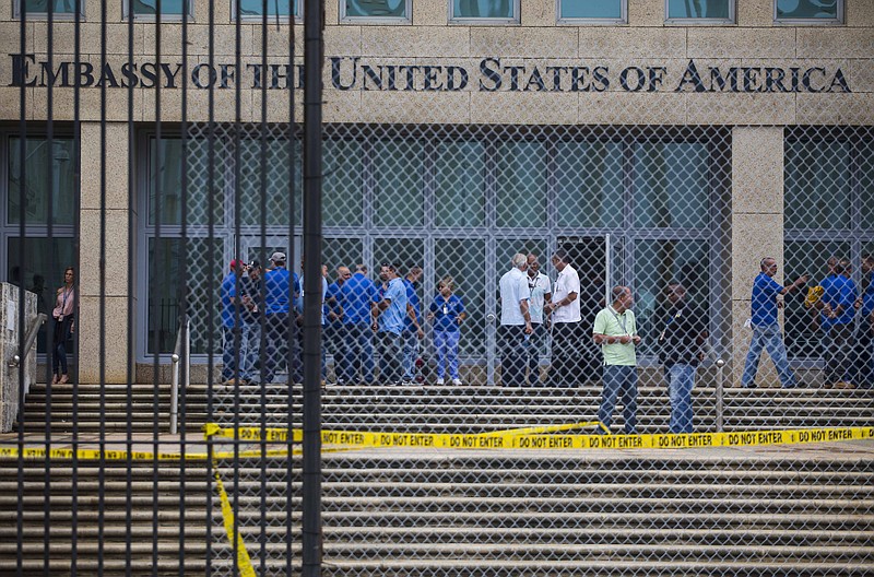 
              FILE - In a Friday, Sept. 29, 2017 file photo, staff stand within the United States embassy facility in Havana, Cuba. The terrifying attacks in Cuba overwhelmingly hit U.S. intelligence operatives in Havana, not ordinary diplomats, when they began within days of President Donald Trump’s election, The Associated Press has learned.  To date, the Trump administration largely described the victims as U.S. Embassy personnel or “members of the diplomatic community,” suggesting it was bona fide diplomats who were hit. That spies, working under diplomatic cover, comprised the majority of the early victims adds an entirely new element of mystery to what’s harmed at least 21 Americans over the last year.  (AP Photo/Desmond Boylan, File)
            