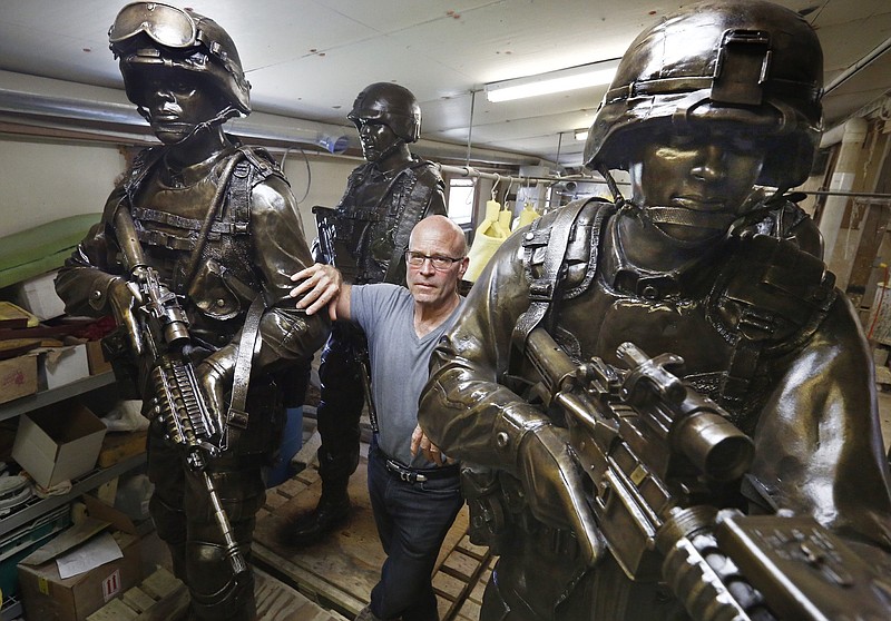
              Alan Cottrill, a well-known Zanesville, Ohio sculptor, has been commissioned by the National Infantry Museum in Georgia to do nine 7-foot sculptures of combat soldiers for the Global War on Terror Memorial. Cottrill poses in his studio with some of the finished statues  on Thursday, September 21, 2017. (Fred Squillante/The Columbus Dispatch via AP)
            