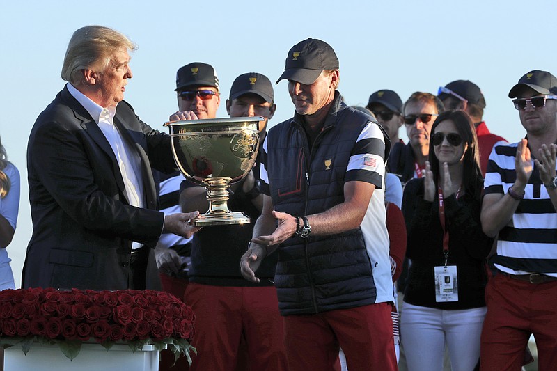 
              President Donald Trump, left, presents the winner's trophy to U.S. Team Captain Steve Stricker after the final round of the Presidents Cup golf tournament at Liberty National Golf Club in Jersey City, N.J., Sunday, Oct. 1, 2017. (AP Photo/Julio Cortez)
            