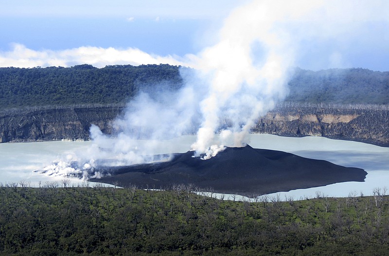 
              This Sunday, Oct. 1, 2017 photo provided by GeoHazards Divison, Vanuatu Meteorological and GeoHazards Department, shows an aerial view of the volcanic cone that has formed in Lake Vui near the summit of Ambae Island, Vanuatu. The evacuation of the Vanuatu island was continuing on Monday, Oct. 2, 2017 even after scientists said an erupting volcano had stabilized. A makeshift fleet of vessels ranging from large landing craft to tiny water taxis was moving thousands of people from Ambae island to other nearby islands in the Pacific archipelago. (Brad Scott/GeoHazards Divison, VMGD via AP)
            