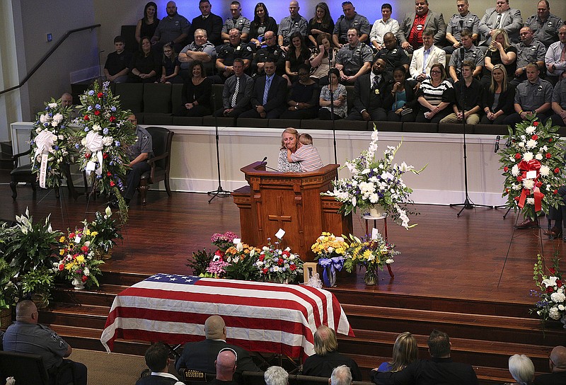 Patricia Tinney Brewer, the mother of slain Polk County police detective Kristen Hearne, and Hearne's surviving 3-year-old son Isaac make an emotional eulogy from the podium during her funeral attended by hundreds of law enforcement officials, family, and friends on Tuesday, Oct. 3, 2017, at the Victory Baptist Church in Rockmart, Ga. Hearne was killed while acting as a backup on what appeared to be a routine stolen car investigation when she was ambushed by a Walker County man with a long rap sheet and an outstanding warrant for his arrest. (Curtis Compton/Atlanta Journal-Constitution via AP)