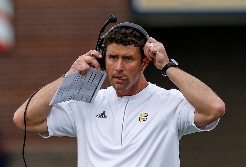UTC head football coach Tom Arth puts on his headset after a timeout during the Mocs' home football game against the Furman Paladins at Finley Stadium on Saturday, Oct. 7, 2017, in Chattanooga, Tenn.