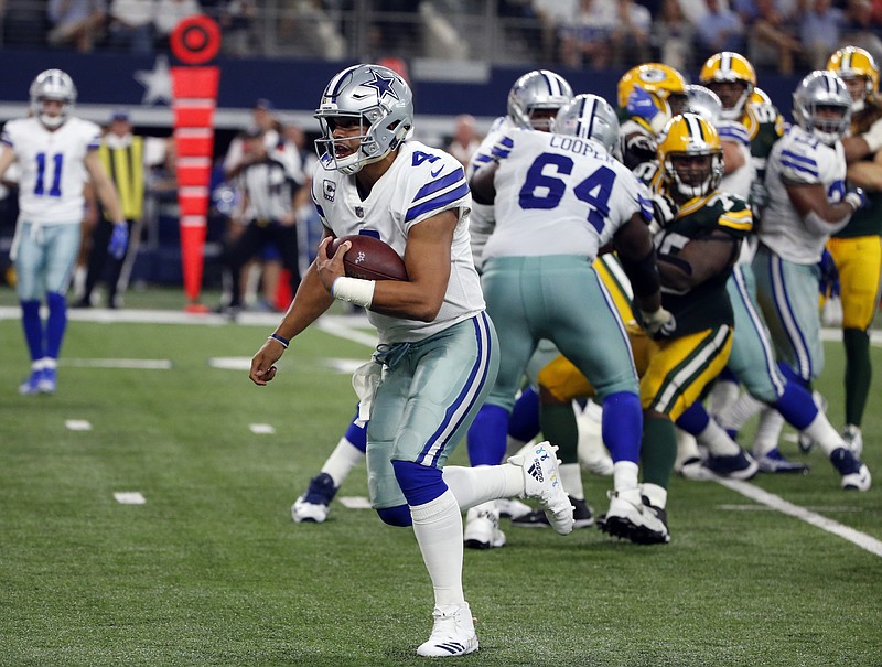 
              Dallas Cowboys quarterback Dak Prescott (4) keeps the ball and runs for a touchdown against the Green Bay Packers in the second half of an NFL football game, Sunday, Oct. 8, 2017, in Arlington, Texas. (AP Photo/Michael Ainsworth)
            