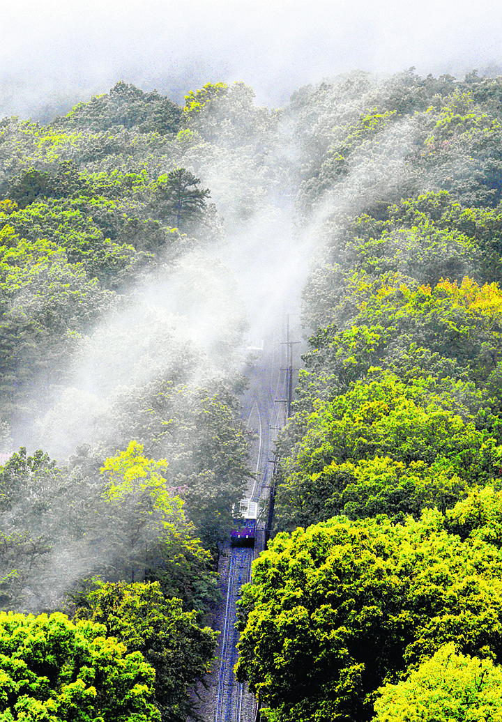 With the first tints of fall in the trees, remnants of Hurricane Nate flow along the slope of Lookout Mountain the Incline Railway makes its foggy descent down the mountain to its valley terminus at the St. Elmo Avenue Station on October 8, 2017.  The railway, now owned by the Chattanooga Area Regional Transportation Authority, began as Incline Number 2 in 1895 and is 1,972 feet long and rises 1,450 to its East Brow Avenue station atop the mountain.   