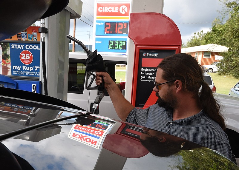 Brandon Guillory, of Walker, La., completes filling his tank with fuel at the Circle K Exxon on Cummings Highway Monday. "Gas is at these prices back home," Guillory said. "We're just headed home from Montgomery County, Pa. after a dog show."
