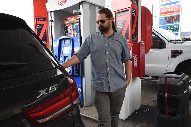 Brandon Guillory, of Walker, La., fills his tank with fuel at the Circle K Exxon on Cummings Highway Monday. "Gas is at these prices back home," Guillory said. "We're just headed home from Montgomery County, Pa. after a dog show."
