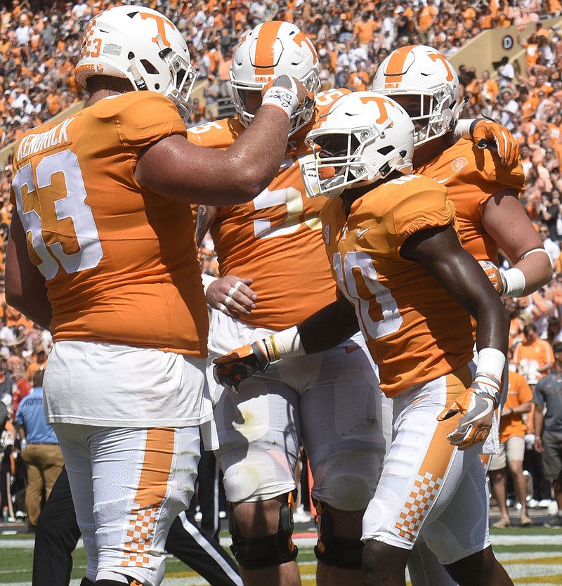 Tyler Byrd (10) is congratulated by Brett Kendrick (63) and other Vols linemen after Byrd scored a touchdown in a football game against the Massachusetts Minutemen in Knoxville on Sept. 23, 2017.