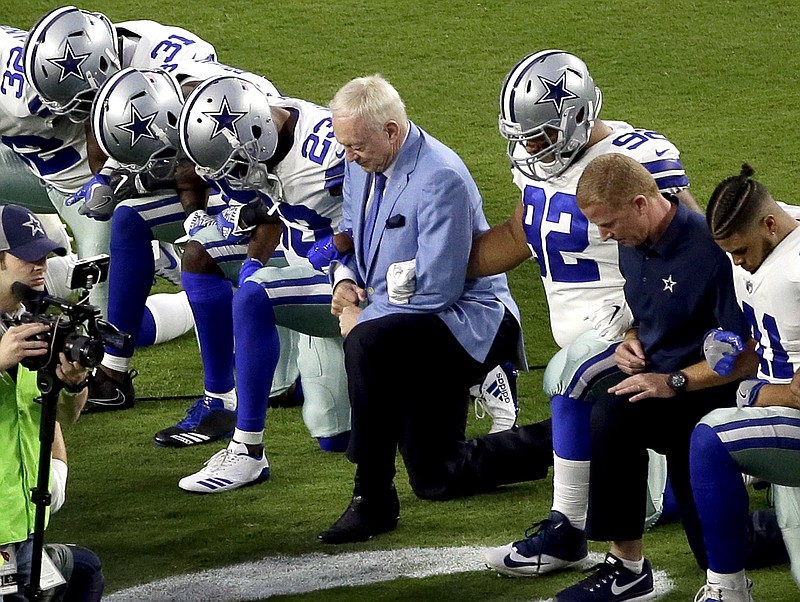 Dallas Cowboys owner Jerry Jones, center, kneels with his team during the national anthem on Sept. 25 but now says he'll bench players who kneel in the future.
